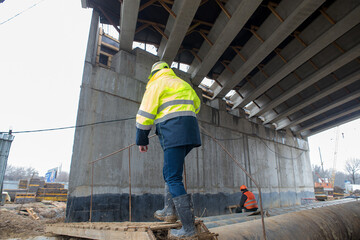 foreman moves around the construction site during the construction of a reinforced concrete bridge
