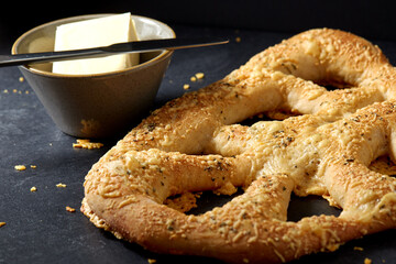 food, baking and cooking concept - close up of cheese bread, butter in bowl and knife on kitchen table