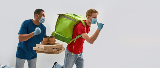 Multiracial young couriers running sideways with boxes