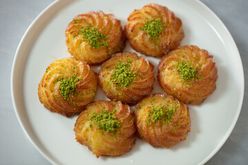 Turkish and Arabic Traditional Ramadan Dessert Lor Cheese Dessert with pistachio powder and syrup serving on plate. High quality photo