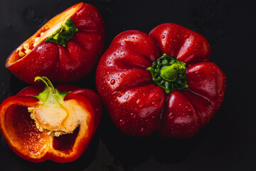 Fresh red bell pepper on black background. Top view Tropical abstract background. Cloe up Pepper vegetaibles with drops of water.