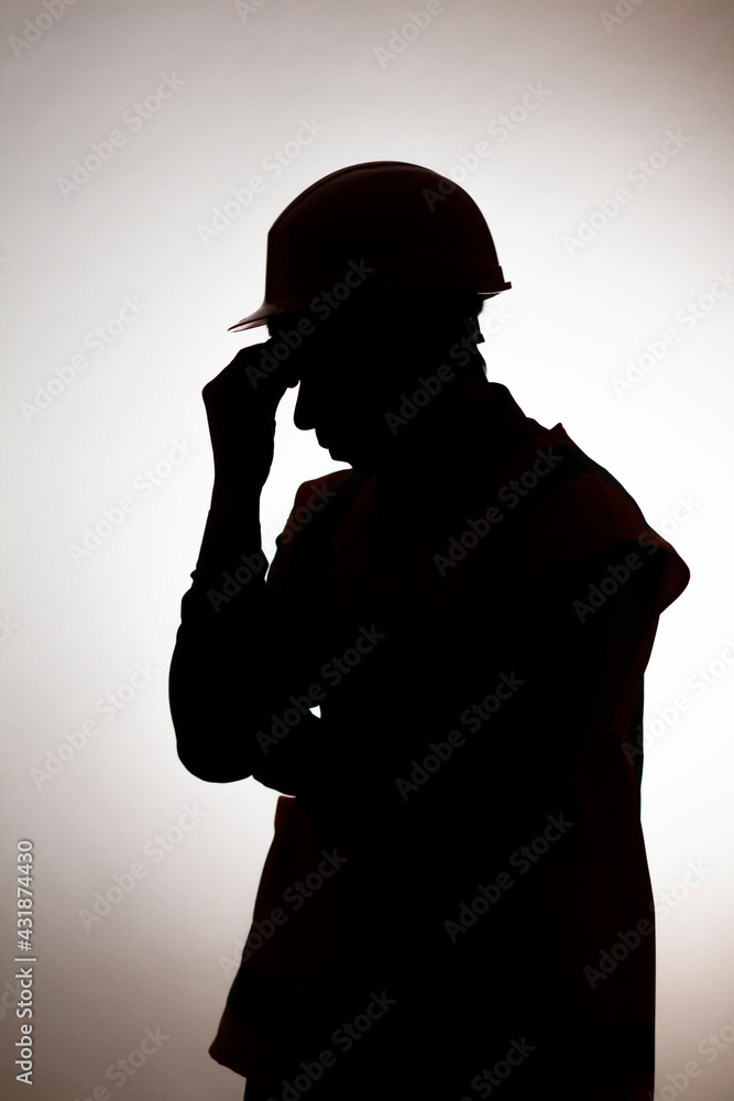 Wall mural silhouette of tired builder bowed head in emotional stress on depressive isolated background, male u