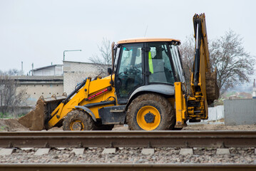yellow construction excavator moves to a construction site