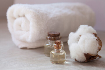 Fototapeta na wymiar cotton essential oil with white towel background