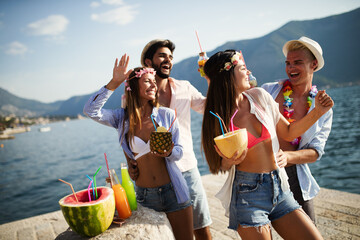 Group of friends at beach drinking and having fun. Summer party.