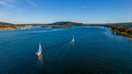 Afternoon aerial waterscape over the bay with high clouds and boats