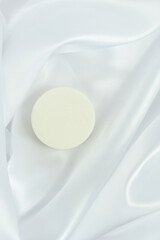 White solid soap shampoo bar on silk background, bath cosmetics