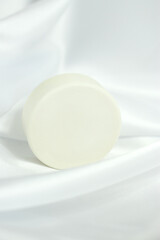 Fototapeta na wymiar White solid soap shampoo bar on silk background, bath cosmetics