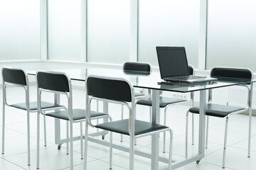 Laptop on glass table in office bright space