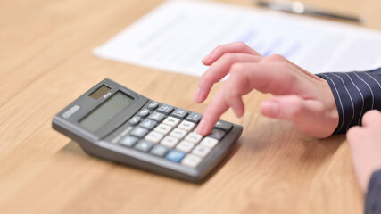 Close up of Female Hand using Calculator