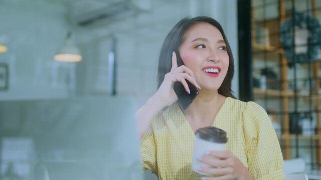 young attractive asian female wear casual cloth hand use smartphone and laptop device comminication social contact in cafe restaruant sit at counter next to big window daylight