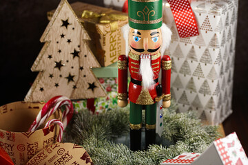A christmas decoration figurine - nutcracker surrounded by presents and christmas wreathe