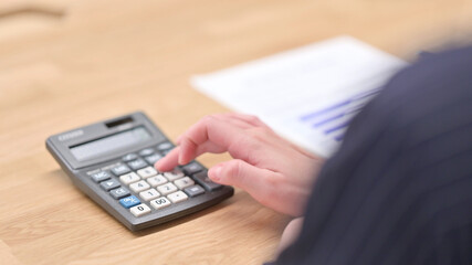 Female Hands Using Calculator in Close up