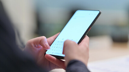 Rear View of Female Hand using Smartphone, Text Messaging 