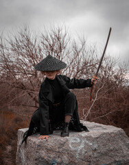 Samurai girl with katana in the forest