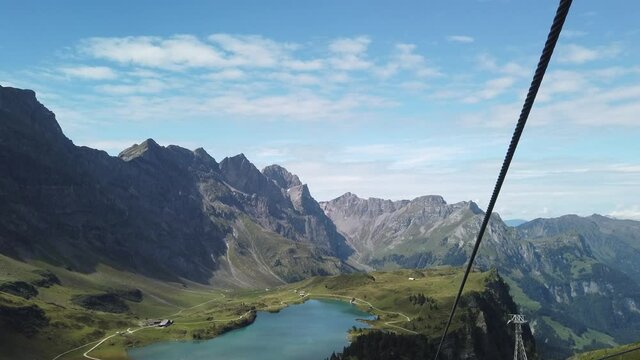 Valley of Engelberg with Truebsee lake. View from cable car to Titlis mountain of the Uri Alps. Located in cantons of Obwalden and Bern, Switzerland, Europe. Summer season, clear blue sky.