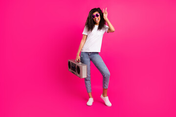 Full length body size view of lovely cheery girl holding player showing v-sign isolated over shine pink fuchsia color background