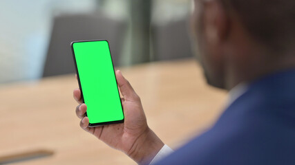 African Businessman Hand Holding Smartphone with Green Screen