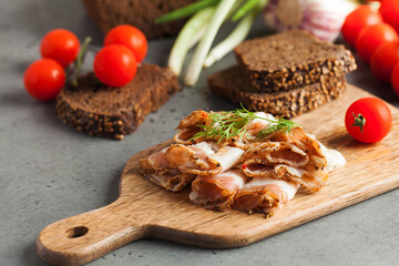 Ukrainian lard, pork lard, sprinkled with fresh chopped herbs on a wooden board