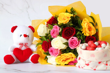 Bouquet of flowers, colorful sugar candies, and a cute teddy bear. A perfect gift combo for birthday and happy valentine's day. Rose flowers. I love you. Happy mothers day greetings. copy space.