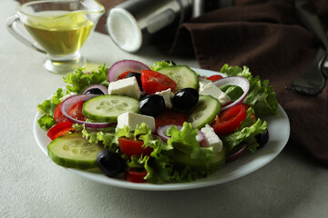 Concept of delicious food with Greek salad on white textured background