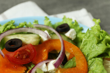 Plate of Greek salad and kitchen towel, close up