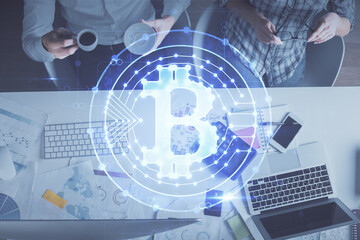 Double exposure of man and woman working together and crypto theme hologram drawing. Computer background. Blockchain concept. Top View.