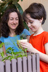 A child with his mother is choosing home plants in the store