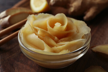 Tray with pickled ginger, chopsticks and ginger on wooden table