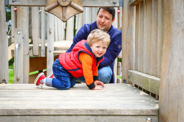 Walking father and son on the playground in the park. 