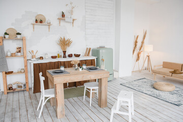 the interior of the kitchen is in a light rustic natural style with a table, chairs and decorative elements