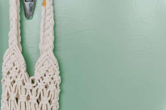retro refrigerator background painted with green paint, wicker eco bag hanging on a metal handle