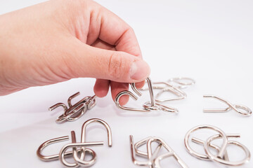 Close-up metal puzzle in hand on white