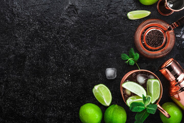 Moscow Mule. Preparation cocktail  with ginger beer, vodka, lime and ice. Copper bar tools. Black bar counter. Top view