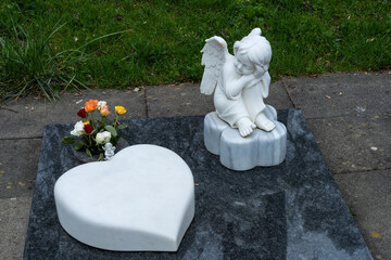 Grabschmuck mit Herz und Engel auf einem Friedhof