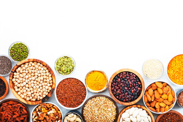 Set of superfoods, legumes, cereals, nuts, seeds in bowls on white background. Superfood as chia, spirulina, beans, goji berries, quinoa, turmeric and other. Copy space, top view