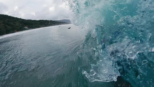 Surf photographer. Man with camera in underwater housing takes picture of the breaking wave
