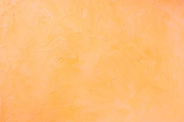 Pastel orange color textured background with plastered effect. 