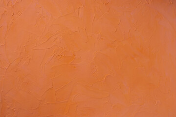 Orange colored textured backdrop, orange stucco background,  red textured wall.