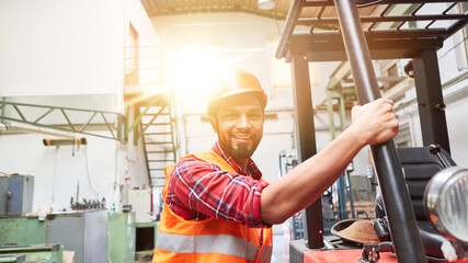 Forklift driver in training on forklift in factory