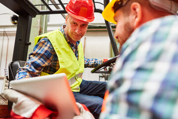 Forklift driver and warehouse clerk at the forklift © Robert Kneschke
