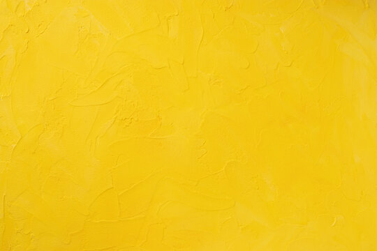 Honey shade yellow textured backdrop. Plaster effect on concrete wall close up.