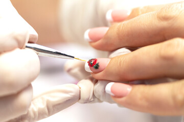 Manicure. Covering natural nails with gel polish, white french coat and nail design in a beauty salon by a manicure master. Close-up