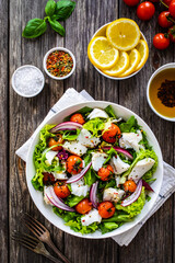 Fish dish - fried cod fillet with vegetables on wooden table
