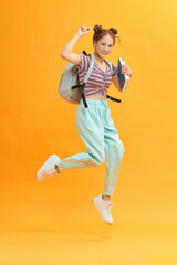 Fototapeta na wymiar Casual female student running. isolated on yellow background