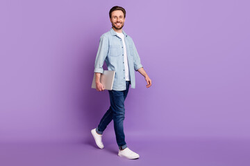 Full size photo of happy cheerful smiling businessman go walk with laptop in hands isolated on purple color background