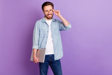 Fototapeta premium Photo of attractive happy charming man wear glasses laptop smile isolated on purple color background