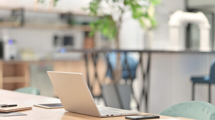 Empty Creative Office with Open Laptop on Table