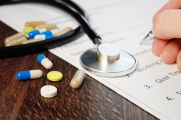 pills and stethoscope and hand signs the medical Insurance, Insurance agent holding pen medical...