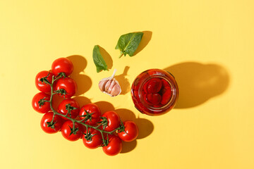 Homemade DIY natural tomatoes with basil and pepper on yellow background